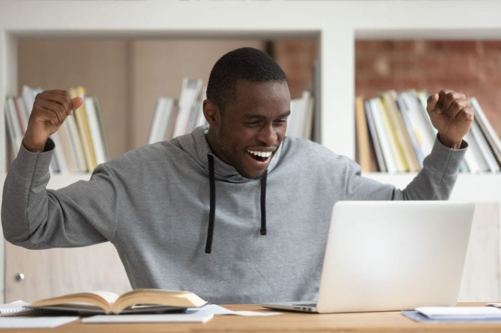 Man Celebrating at Desk with Laptop follow up reminder email answered
